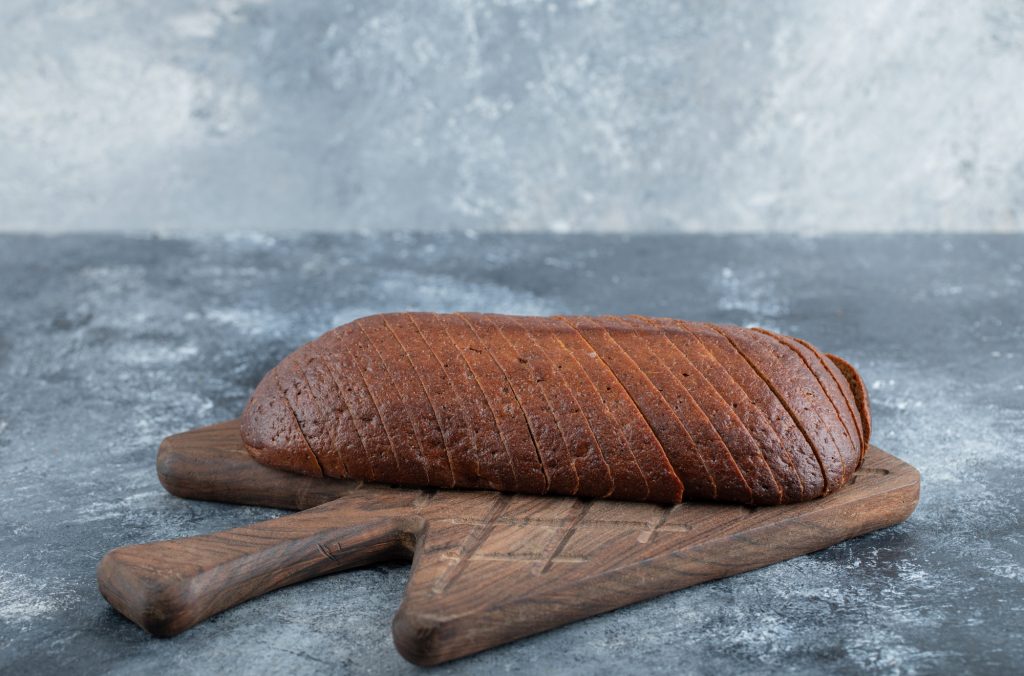 Homemade Organic Pumpernickel Rye Bread Cut into Slices on the wodden cutting board