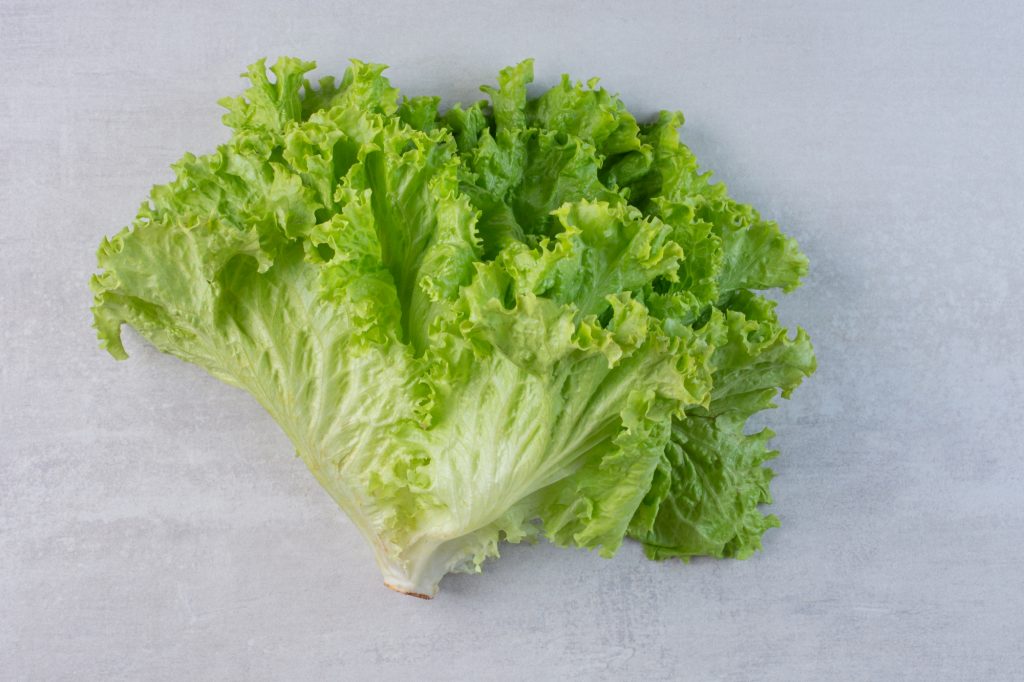 Fresh green lettuce on marble background